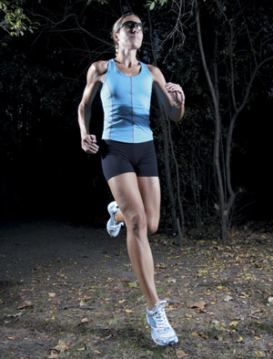 Woman running in the forest at night