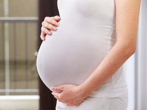 woman holding her belly as she is pregnant